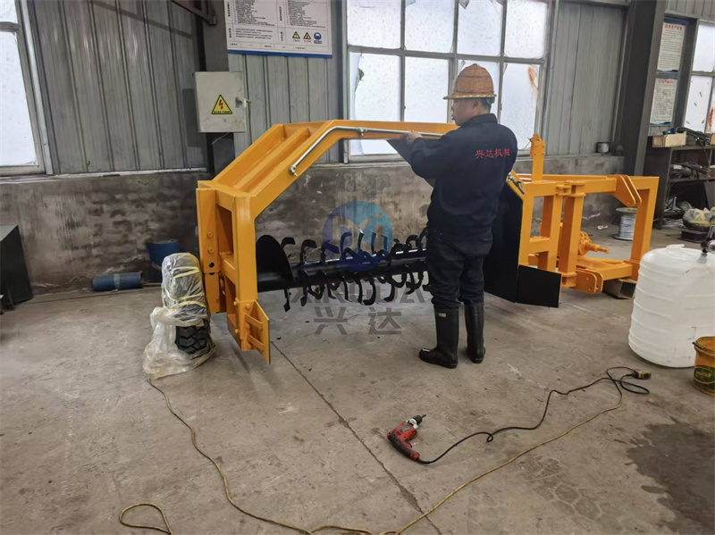 翻抛机出口现场：车间人员正在对有机肥设备牵引式翻抛机进行装车